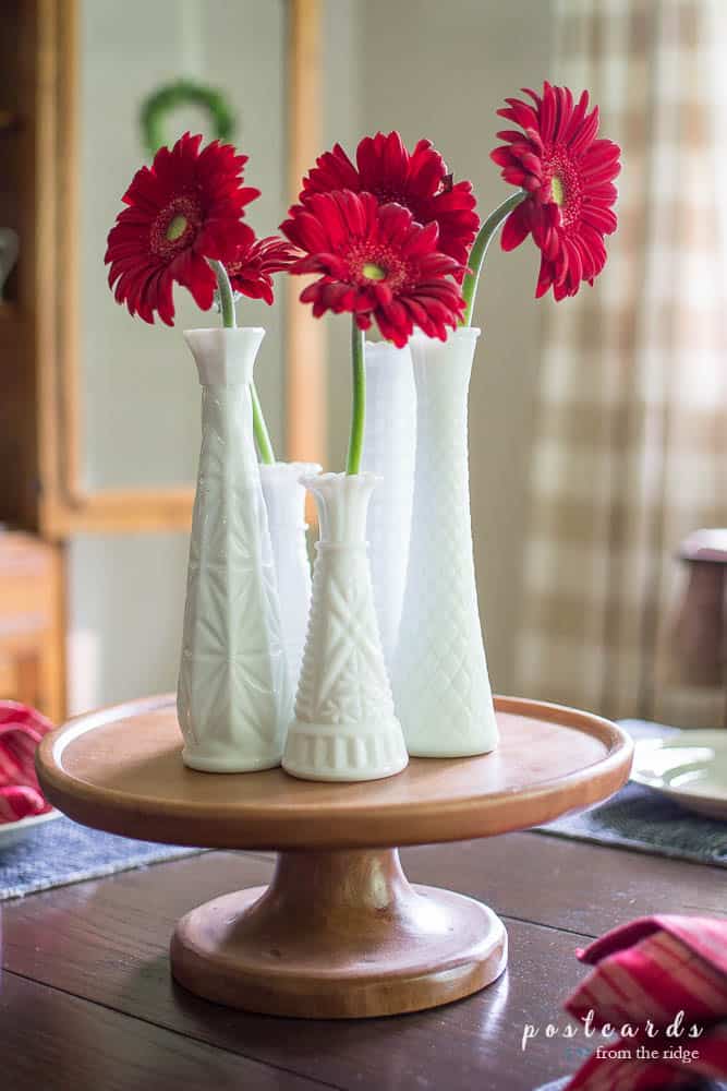 白色牛奶玻璃花瓶里的红色雏菊